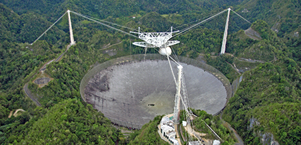 Fig. 2 - Un'immagine del telescopio di Arecibo, fino a poco tempo fa il piu' grande del mondo. Nel 2011 ha scoperto un lampo radio riuscendo a localizzarlo con precisione. Questo ha permesso di scoprire la galassia ospite, distante 2 miliardi di anni luce. E' la prova che i lampi radio sono extragalattici. 