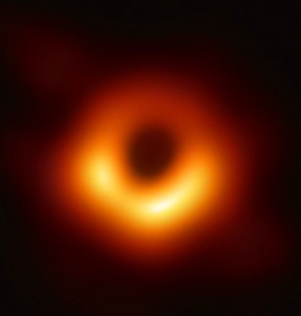 Fig. 1 - La prima storica immagine di un buco nero: il buco nero supermassiccio al centro di Messier 87. Crediti: The Event Horizon Telescope.