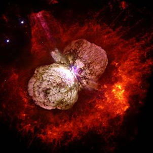 Fig. 2 - Immagine scattata dal telescopio spaziale Hubble che mostra Eta Carinae e la Nebulosa Omuncolo che la circonda. Eta Carinae e' una stella che sta per eslodere e che potrebbe benissimo essere una progenitrice di un Gamma Ray Burst. Dista da noi circa 7000 anni luce, e probabilmente, a giudicare dal suo asse di simmetria, sparera` la sua emissione principale non verso la Terra. Ha preso di mira qualche altro mondo, quindi... per ora possiamo stare tranquilli.